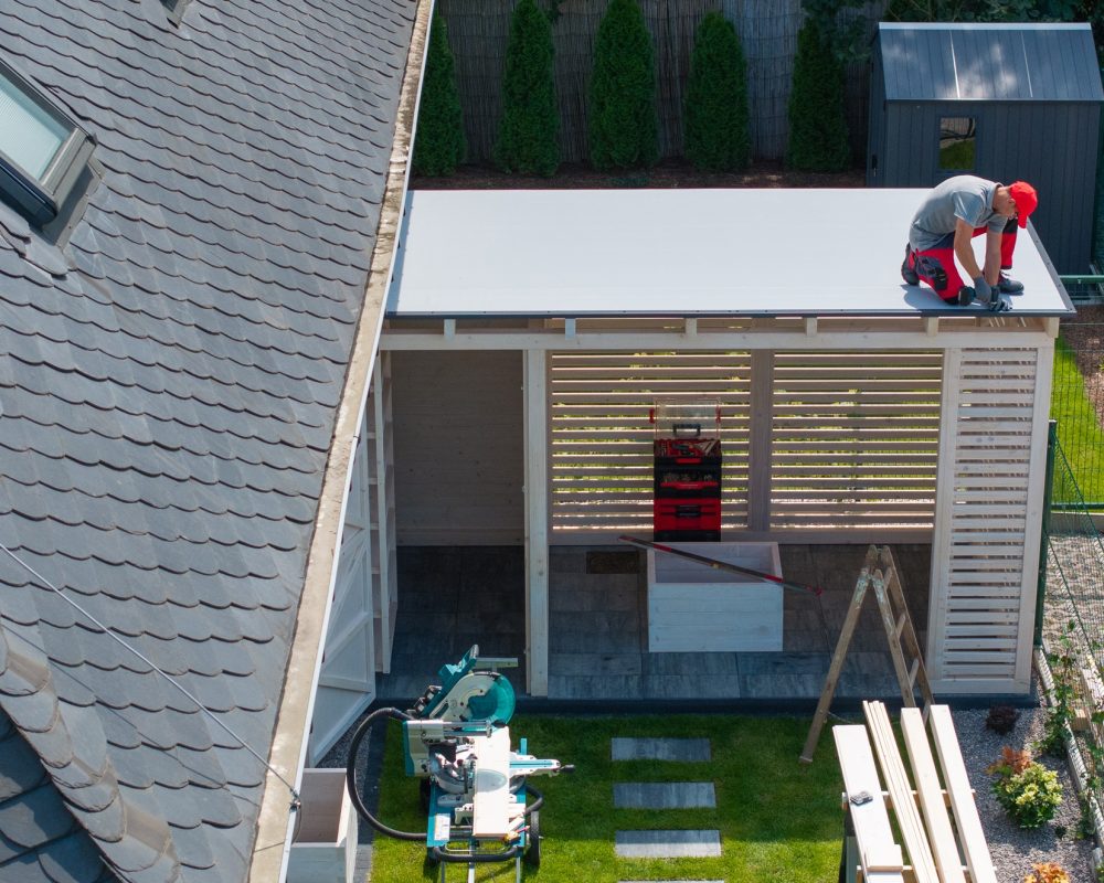 Worker Installing Roof On Patio Structure Worker Installing Roof On Patio Structure